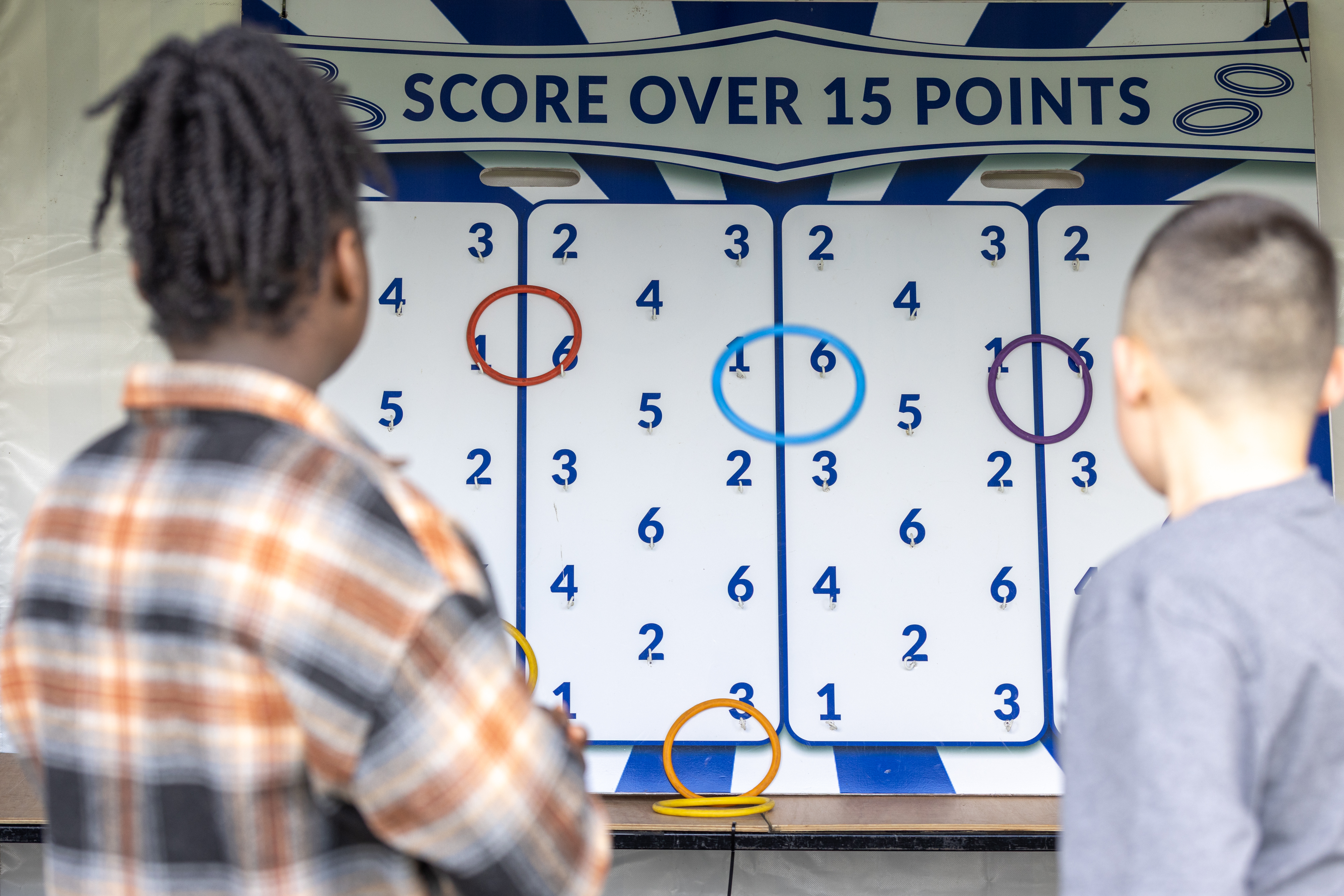 Two people playing a ring toss game. 